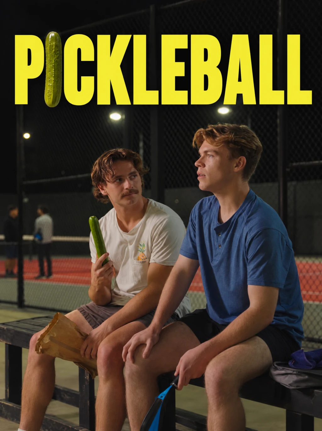 the pickleball one-sheet — two men on a courtside bench at night, one holding a whole cucumber